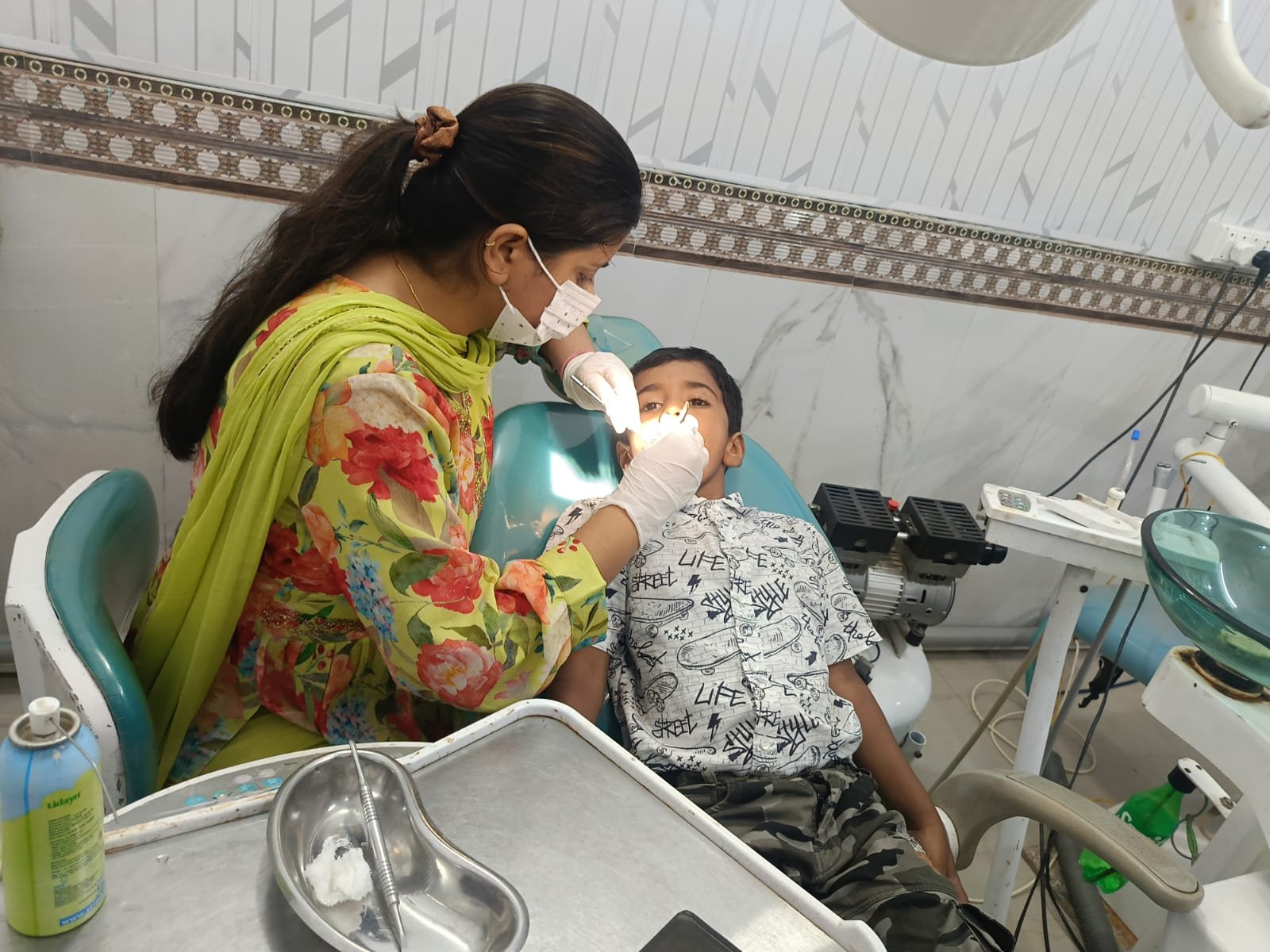 Dentist examining a young child patient in the dental chair